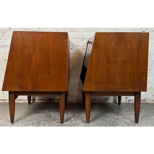 Pair of stylish American Mid-Century walnut night stands manufactured by Carlton House. Similar to designs from the...