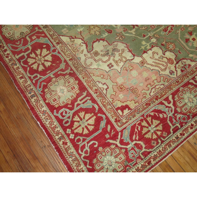 A highly decorative, artistic forest green colored ground Turkish Oushak with a cherry red medallion and border. Beautiful...