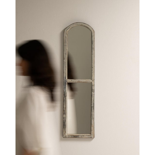 A mirror whose whitewashed/gray distressed frame, tall gives it real character at first glance. It was made in France...