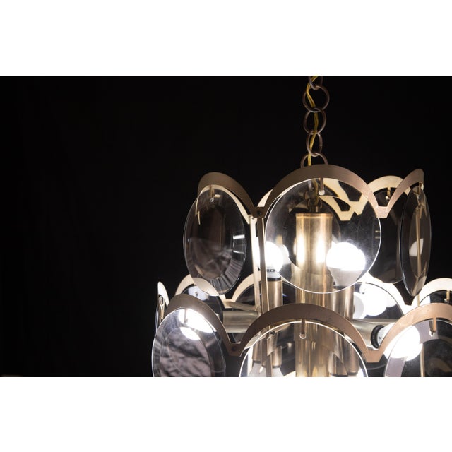 Vintage Italian chandelier with three tiers of smoked glass discs mounted on a brass frame, with a crescent-shaped brass...