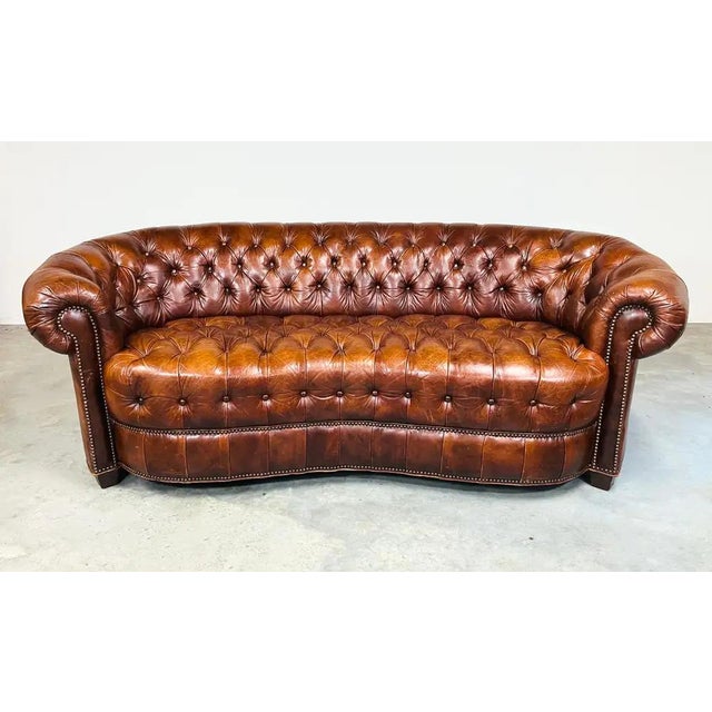 Henredon chesterfield sofa having a dramatic crescent shape featuring deep button tufting across the entire seat,...