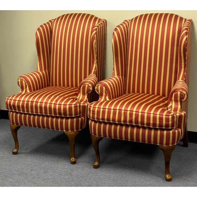 Beautifully proportioned chairs upholstered in a dark salmon pink and matte gold fabric. Figured rolled arms, loose seat...