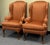 Beautifully proportioned chairs upholstered in a dark salmon pink and matte gold fabric. Figured rolled arms, loose seat...