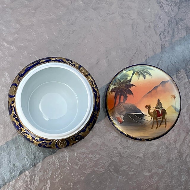 Deco Egyptian Revival Trinket Box/ Powder Jar with a desert scene with a camel. This piece has the Blue Komaru mark which...