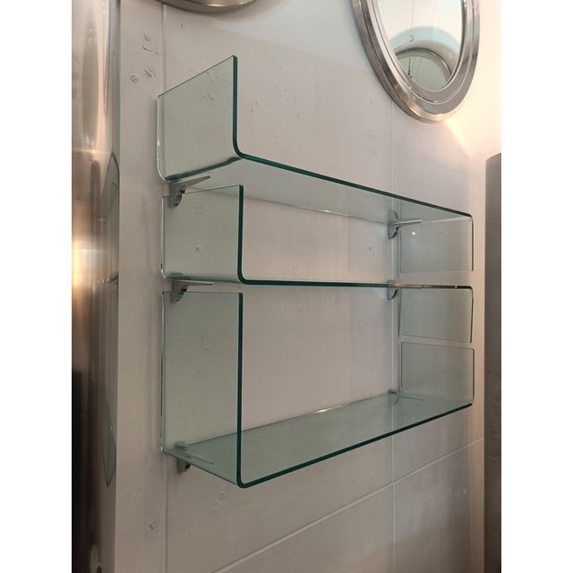 A set of three Mod. Babila wall shelves in curved glass with chrome-plated metal brackets, manufactured by Fiam Italia....