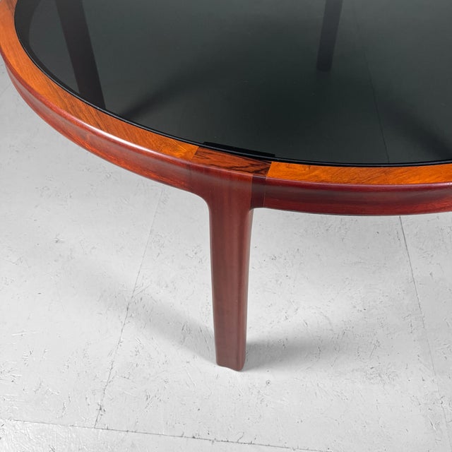 Large Mid Century coffee table with a fumed glass top. Beautifully designed wooden veneer frame. Dimensions: height 48 cm,...