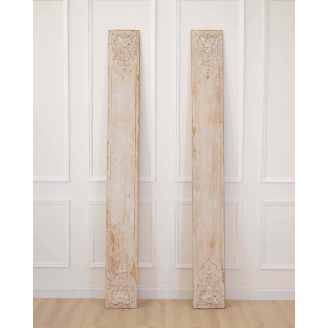 An elegant pair of antique French boiserie panels featuring beautifully carved Rococo-inspired ornamentation and a softly...