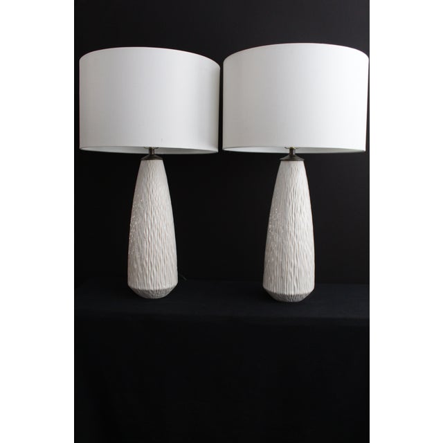 Beautiful pair of Fornasetti influence table lamps.. Ivory embossed ceramic. Sculptured texture and depth. Graceful shape....