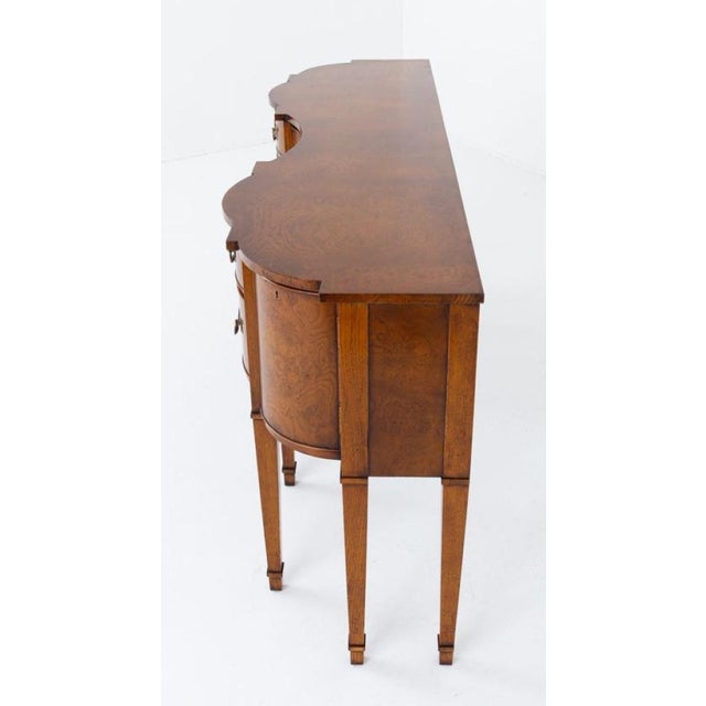 Georgian style figured oak shaped sideboard Circa 1900 The sideboard is raised upon 8 elegant tapered legs with ebony line...