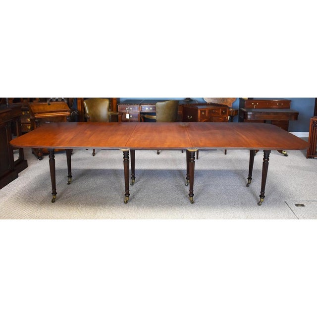 Regency mahogany dining table in good condition, stands on eight elegant reeded legs all fitted with brass castors. The...