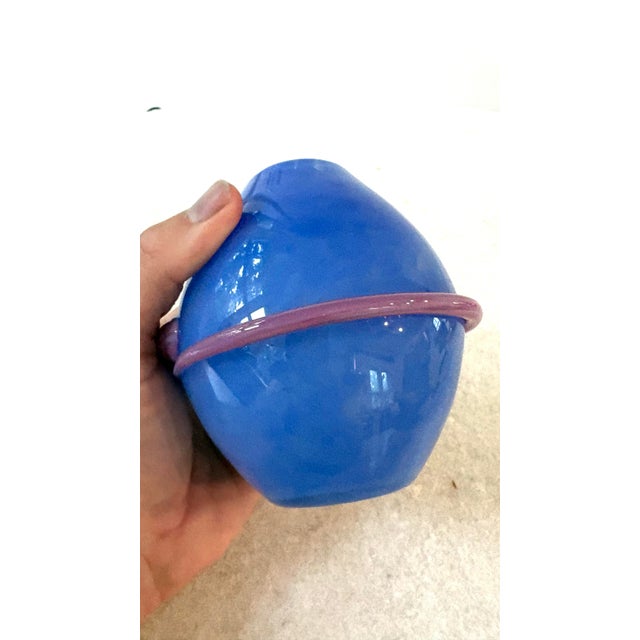 This striking hand-blown art glass vessel resembles a Saturn or planet-style vase crafted by the renowned Maui-based...