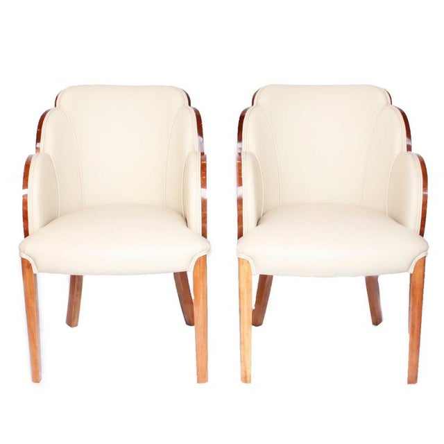A pair of art deco cloud back armchairs, re-upholstered in cream leather and alcantara suede. Dimensions: h 85cm, w 57cm,...