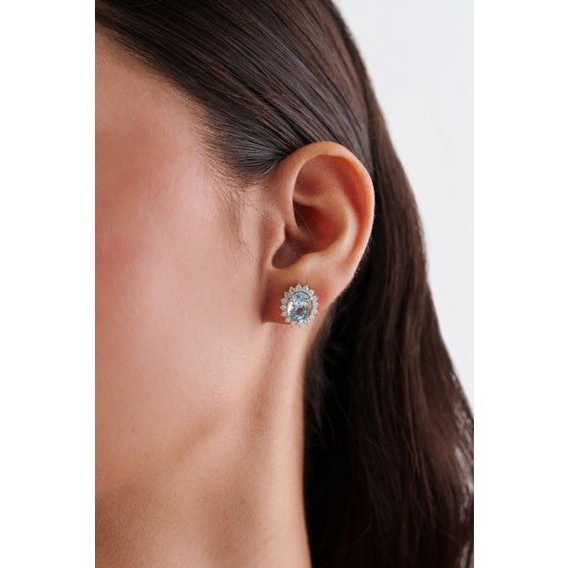 These Halo Stud Earrings, Showcasing 3.72 carats of natural oval aquamarines, set in 14K white gold. Each aquamarine...