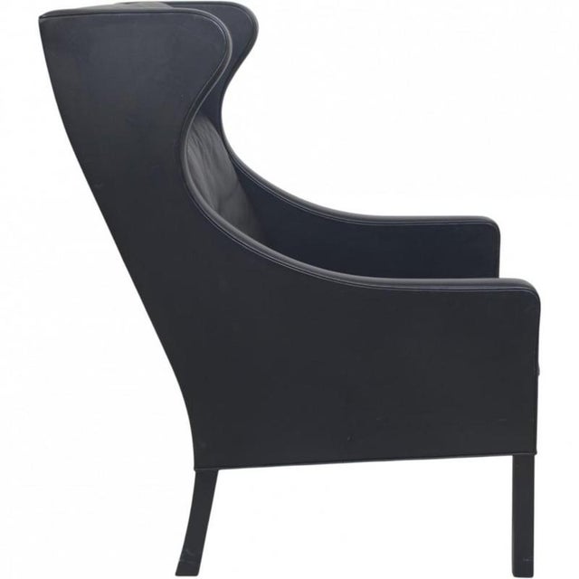 Børge Mogensen wingchair, model 2204, upholstered in original black leather with down cushions and black legs. The chair...