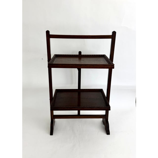 Circa 1900 - 1920s, this solid oak English metamorphic table features two rectangular wood shelves designed to function as...