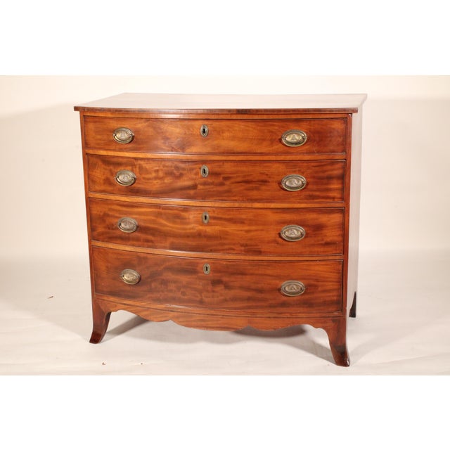 George III or American Federal plum pudding mahogany bow front chest of drawers, circa 1800. With a single board D shaped...