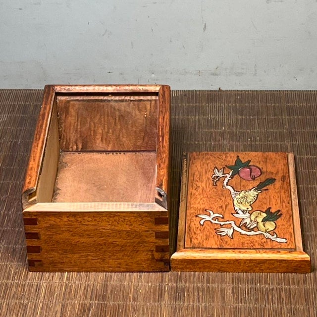 A finely carved wooden sliding drawer box with a rich antique-inspired presence. The front panel features intricate...