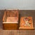 A finely carved wooden sliding drawer box with a rich antique-inspired presence. The front panel features intricate...
