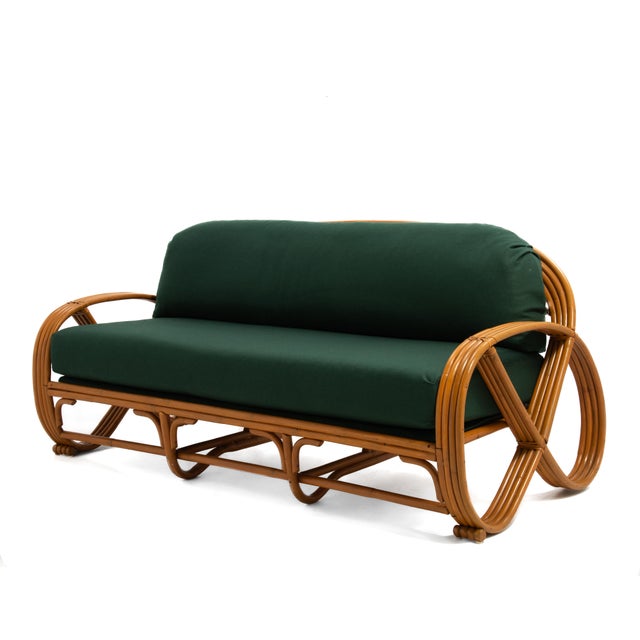 A vintage five piece rattan living room set after Paul Frankl consisting of a three seat sofa, a two seat settee, a coffee...