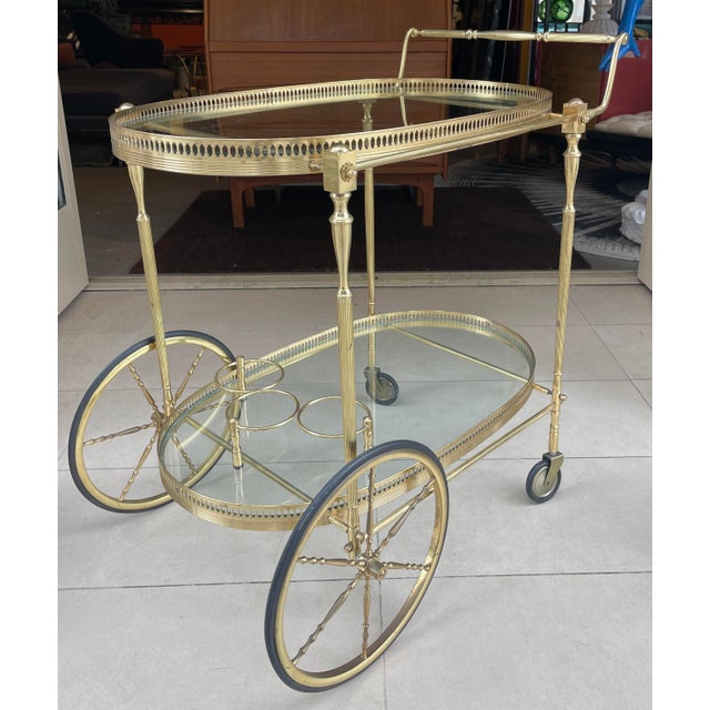Exceptional brass bar cart. Impress your guests with this sleek brass bar cart with holders for three bottles of your...