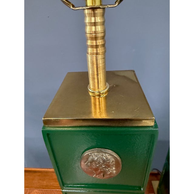 A striking pair of neoclassical-style table lamps featuring bold, architectural column forms finished in a rich emerald...