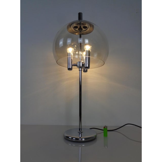 Chrome-plated table lamp with a large, round glass shade. Three lights. Mirrored light bulbs are included. The chrome...