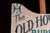 Hand-painted wooden advertising sign for "The Old Howard Burlesque at Scollay Sq." featuring stylized black and teal...