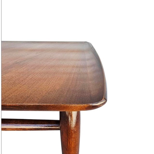 Beautiful vintage modern coffee table features unique raised edges and tapered legs. Sleek design with stretchers between...