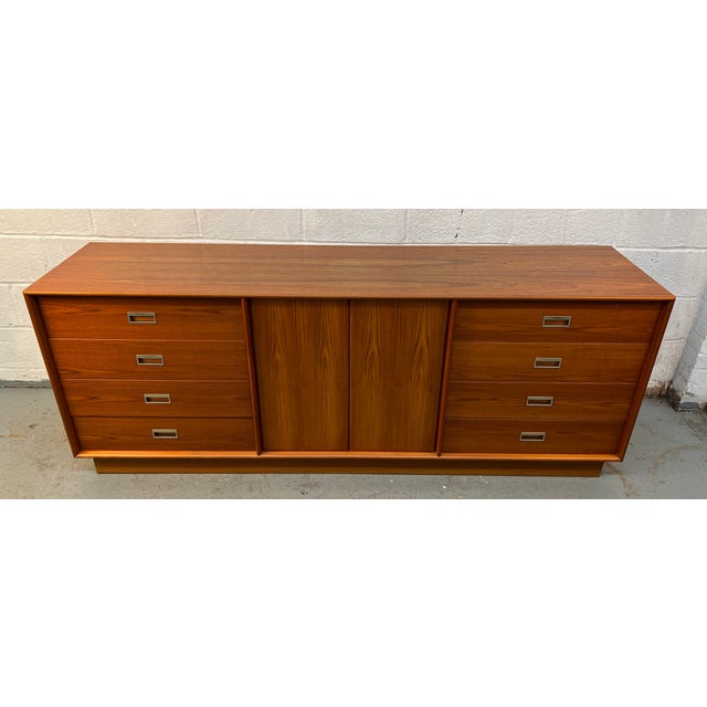 Stunning mid-century modern Danish teak wood dresser featuring eight spacious drawers and timeless Scandinavian design....