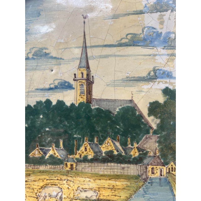 Delftware plaque with a scalloped edge Decorated in shades of blue Depicts a Dutch village Old restorations, see photos...
