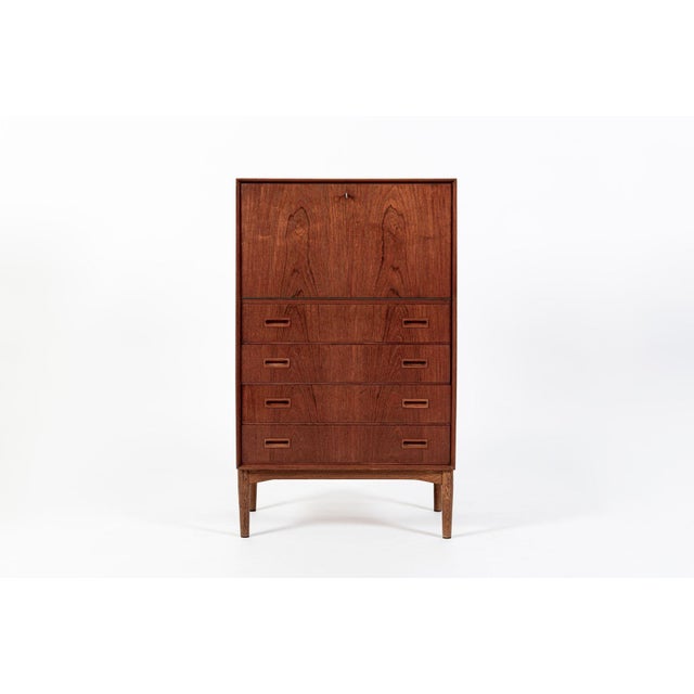 This vintage mid-century Danish modern teak secretary desk or bar cabinet was made in Denmark in the 1960s. The cabinet...