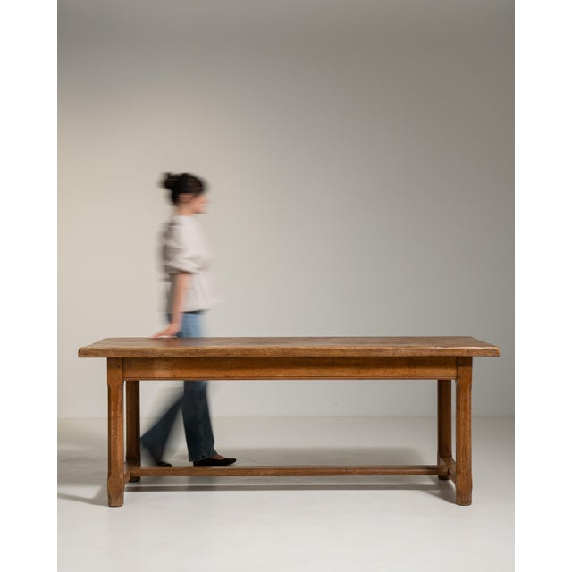 A traditional trestle table derived from medieval European forms, where detachable bases and long tops allowed for...