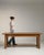 A traditional trestle table derived from medieval European forms, where detachable bases and long tops allowed for...