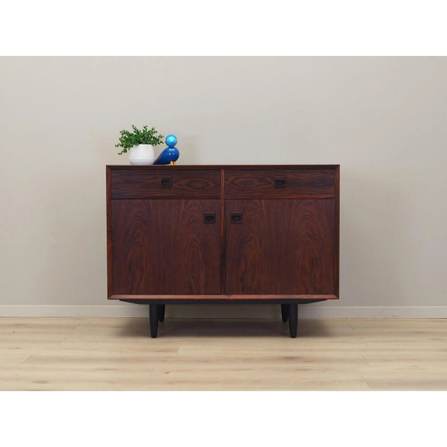 The dresser was made in the 1970s, Danish production. The structure is covered with rosewood veneer. Legs made of solid...