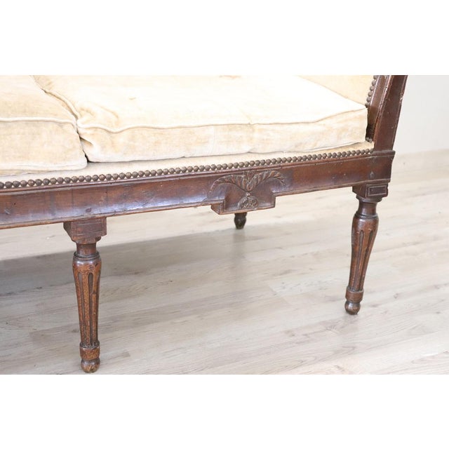Italian antique settee of the period Louis XVI. Made of fine walnut wood and velvet covering, characterized by a simple...