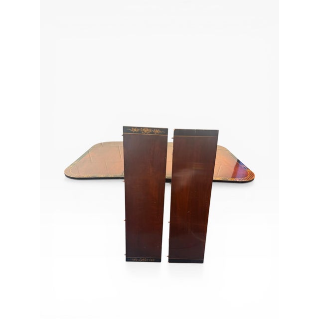 A refined Federal-style drop-leaf dining table crafted in richly toned mahogany, featuring elegant satinwood-style banding...