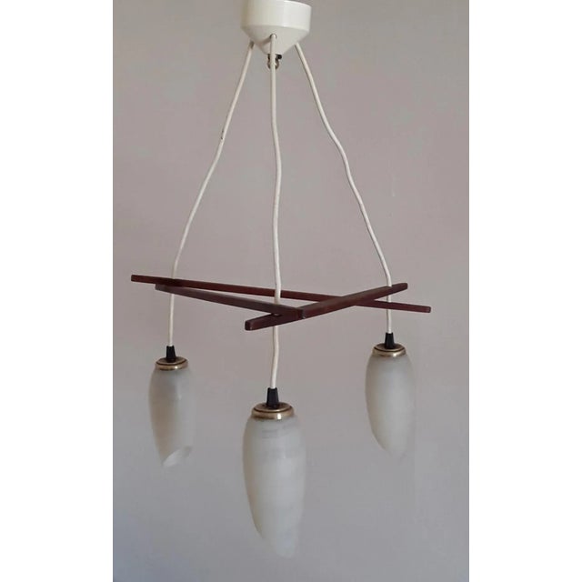 3-light vintage ceiling lamp in Scandinavian style with a rod made of teak wood and beige patterned glass shades from the...