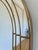 This vintage Belgian mirror dates from the 1980s and features an elegant arched shape with a gold-toned frame. The mirror...