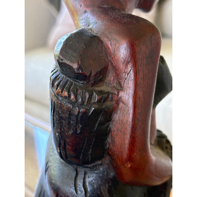 A striking vintage hand-carved East African hardwood sculpture depicting a mother carrying an infant on her back while...