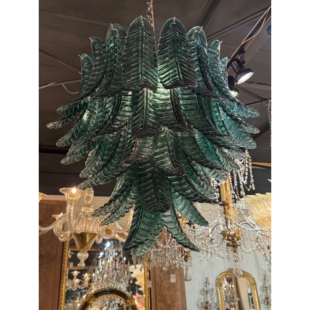 The Modern Palm Leaf Dark Green Murano Glass Waterfall Chandelier is a stunning piece of lighting fixture that adds a...
