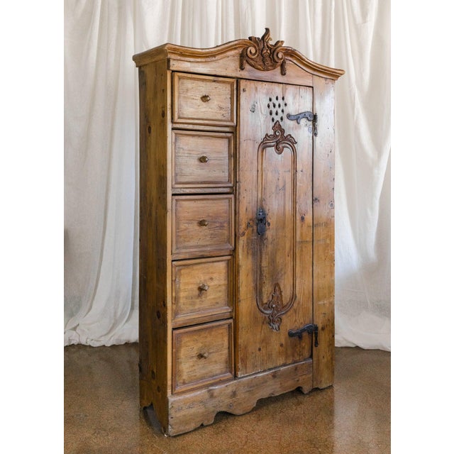 This European pine cabinet showcases a beautiful carved crest and a charming combination of drawers and a cabinet door...