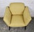 This is a pair of mid-century armchairs. They feature a subtle yellow fabric along with understated black lacquered legs....