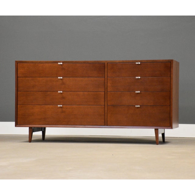 A mid century modern walnut eight drawer designed by George Nelson for Herman Miller with rare aluminum I pulls....