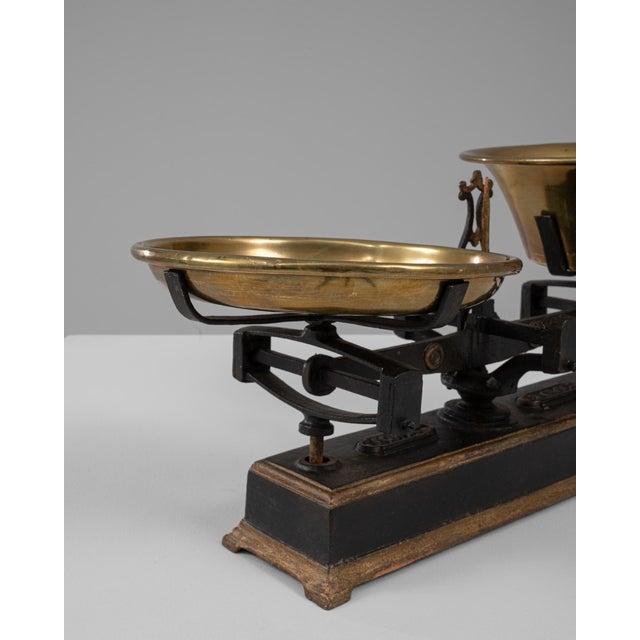 This 19th Century French iron and brass scale showcases a striking blend of utilitarian structure and refined material...