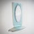 Oval wall mirror set within a rectangular frame with rounded corners, executed in light blue glass with a textured,...