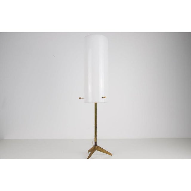Brass and white acrylic glass tripod table lamp, Italy, 1960s. This elegant vintage lamp has a slim brass stem resting on...
