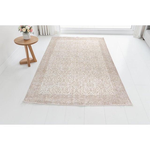 This is a vintage Turkish Oushak rug from the Mid 20th Century. The piece was hand-knotted.