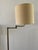 A handsome vintage brass floor lamp in classic library style, featuring a slender stem, an articulating swing arm for...