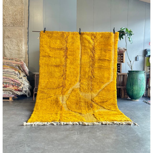 A bold and sophisticated Mrirt rug handwoven from natural wool by Berber artisans. Its rich golden ochre palette and...