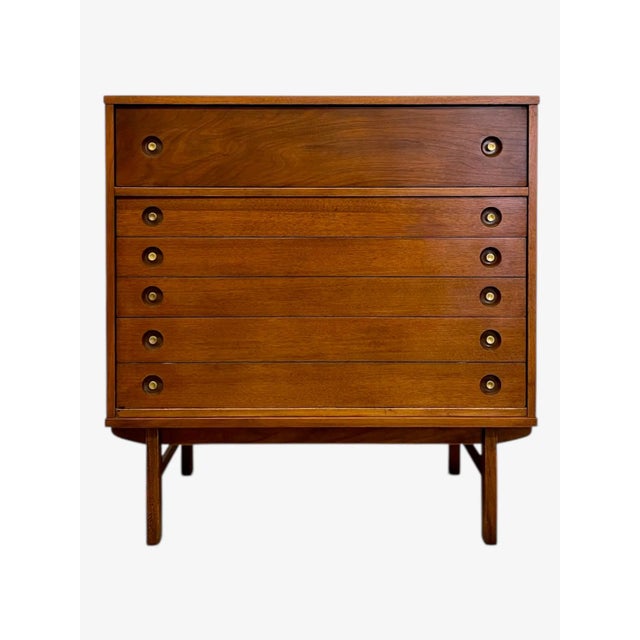 This vintage mid-century modern dresser features clean lines, warm wood grain, and classic craftsmanship characteristic of...